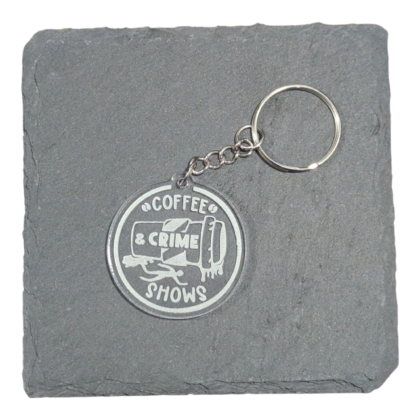 Coffee and Crime Shows image engraved on acrylic keychain displayed on slate tile for contrast