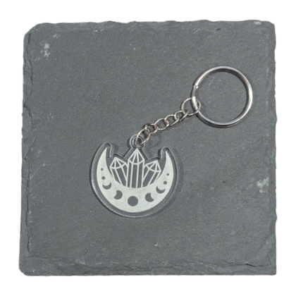 Moon Phases and Crystals Keychain engraved on clear acrylic and displayed on a slate tile for contrast