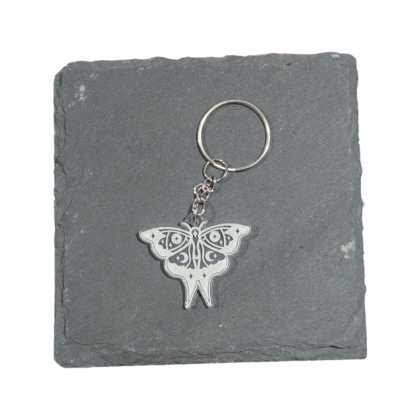 Moth engraved acrylic keychain displayed on slate for contrast