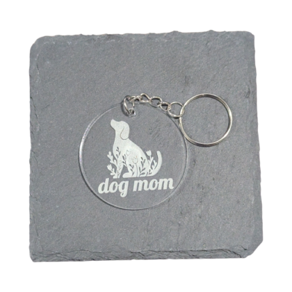 Dog Mom Keychain engraved on clear acrylic and displayed on a slate tile for contrast