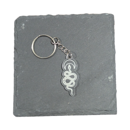 Celestial Snake Moon Keychain engraved on clear acrylic and displayed on a slate tile for contrast