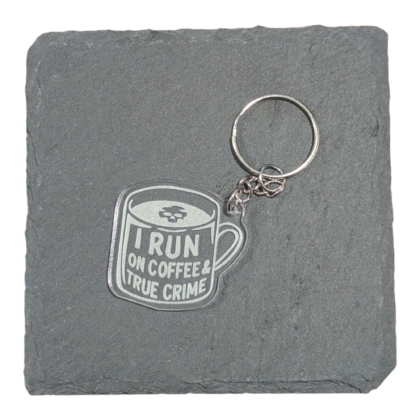 I Run on Coffee and True Crime image engraved on acrylic keychain displayed on slate tile for contrast