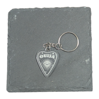 Ouija Planchette Keychain engraved on clear acrylic and displayed on a slate tile for contrast