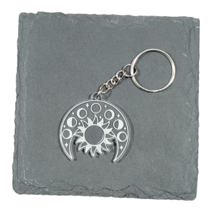 Moon Phases and Sun Keychain engraved on clear acrylic and displayed on a slate tile for contrast